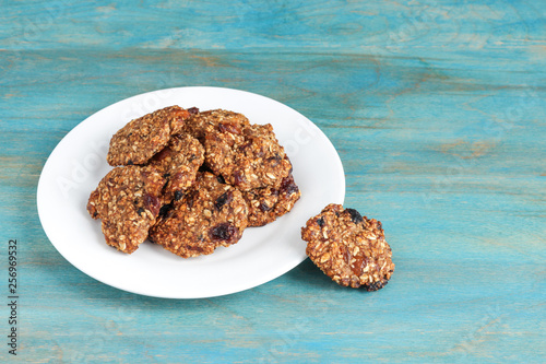home made oat cookies on white plate on blue wooden background