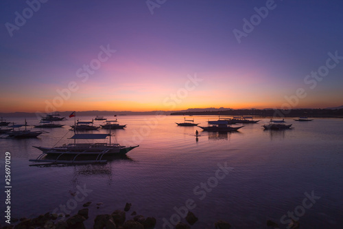 sunset at a bay of water and fishing port, the calm sea in low tide, a tranquil scene in a summer evening vacation mood 