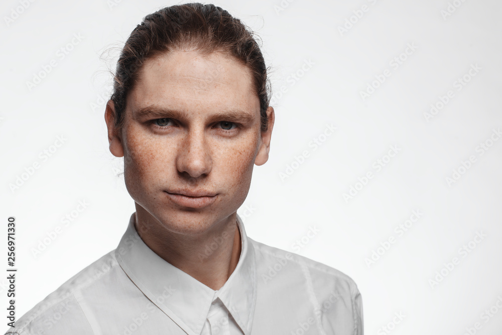 Portrait of a handsome long-haired man with drawn hair and freckles dressed in a white shirt Portrait of a handsome long-haired man with drawn hair and freckles dressed in a white shirt