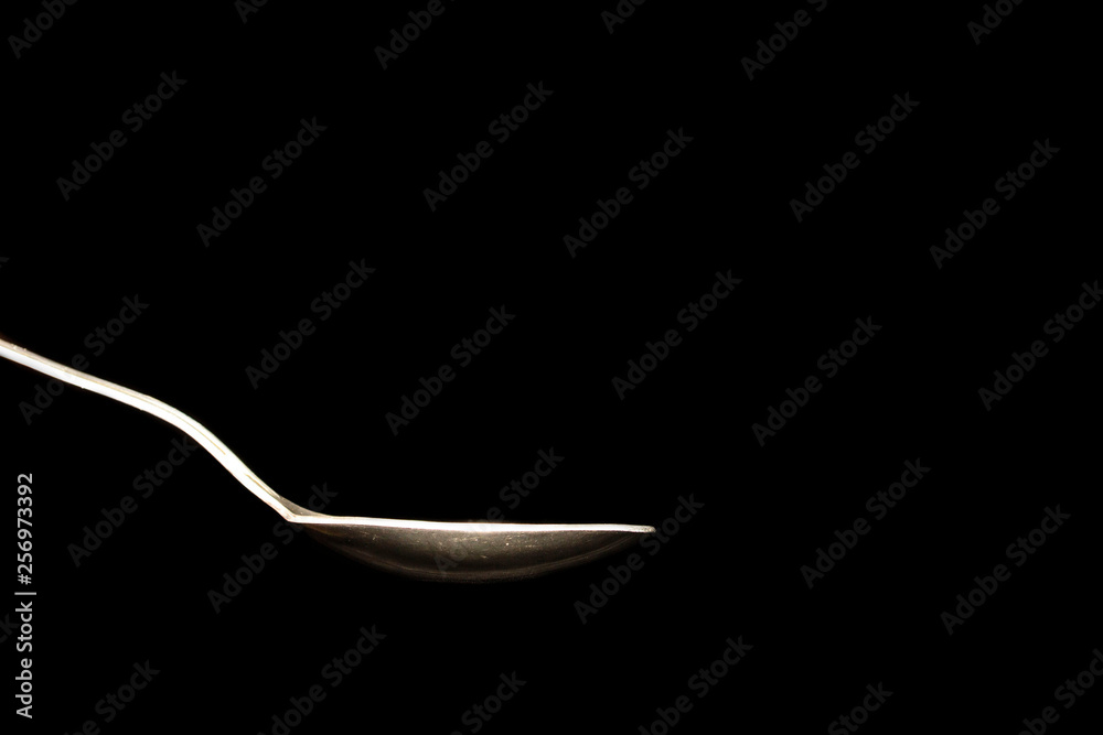 hot steel spoon on black background with steam from water hot steel spoon on black background with steam from water