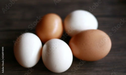 Chicken eggs (brown) and kampong chicken eggs (white) on wood background. Description