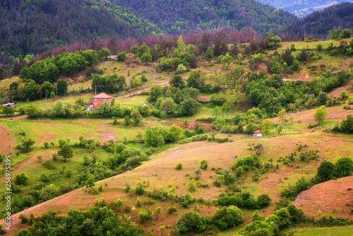 Spring is coming... Amazing spring view with a little village in Rhodopi Mountains, Bulgaria. Magnificent landscape, green fields, small houses. photo