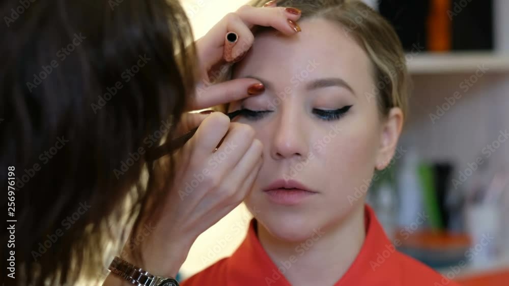 Professional makeup artist working with beautiful young woman Professional makeup artist working with beautiful young woman