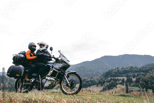 A loving couple on a touristic bike rides on a long journey together. travel, vacation. active lifestyle. View of the mountains and pine forest in the Carpathians Romania