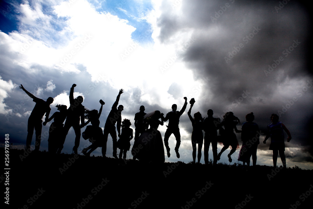 Silhouettes of a group of young people jumping against the sky Silhouettes of a group of young people jumping against the sky