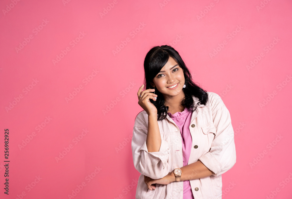 portrait of young asian woman smiling toward camera over pink background portrait of young asian woman smiling toward camera over pink background