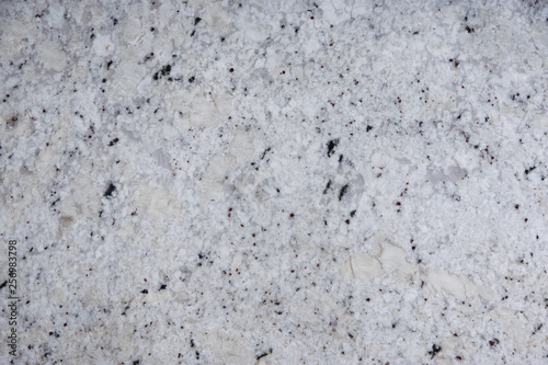 Background natural stone of white color with dark specks, called granite Fantastic White