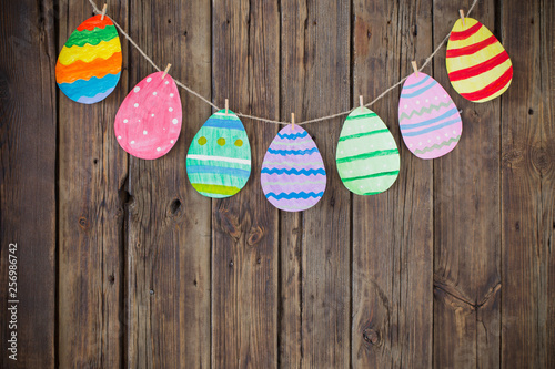 Paper Easter painted eggs painted hang on clothespins on backgr
