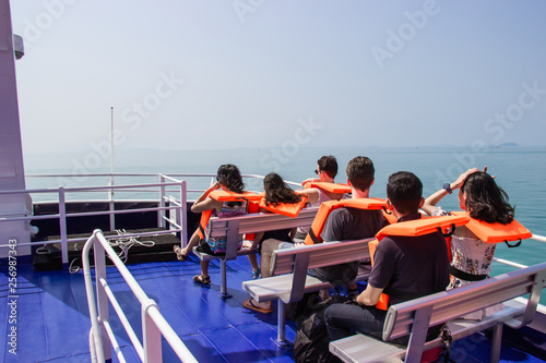 Male and female tourists take a ferry ride for travel relax at Koh Kood island, Trat province. © Pina