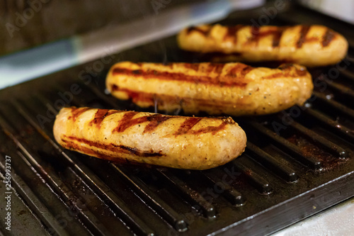 set three sausages with grill bars on grill background grill metal dark black closeup fast food snack street food hot dog