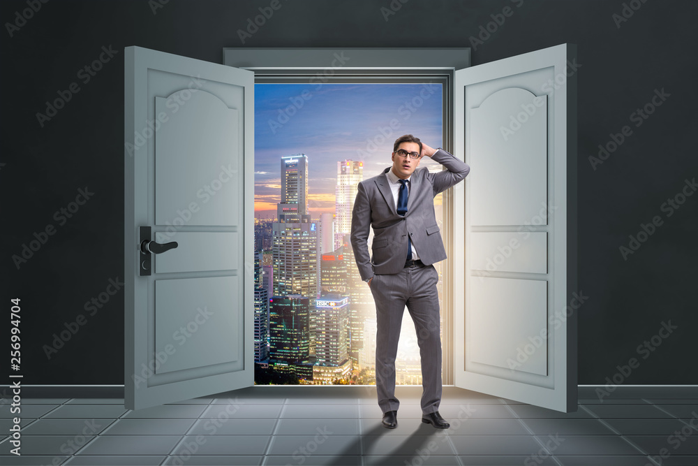 Fototapeta premium Puzzled businessman in front of big door