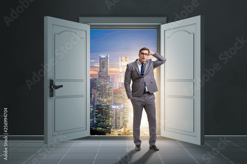 Puzzled businessman in front of big door