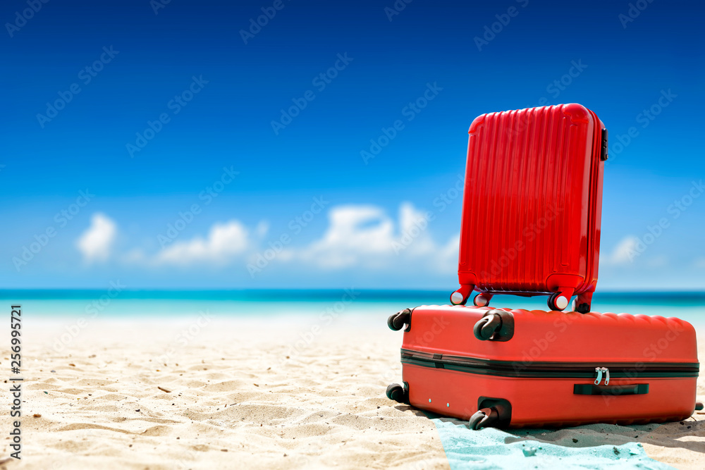 Summer red suitcase on beach and sea landscape. Free space for your decoration. Summer time 