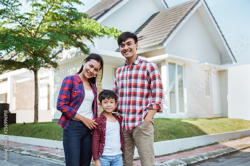 asian family with kid portrait in front of their house together in the morning