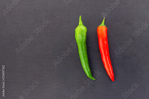 green red chili pepper couple contrasting vegetable couple base menu design on a slate background