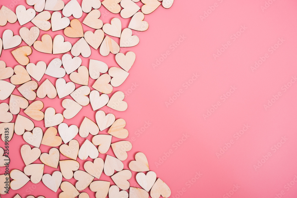 Wood hearts on pink background with copy space,