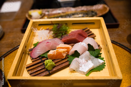 Sushi Sashimi set on a wooden tray.