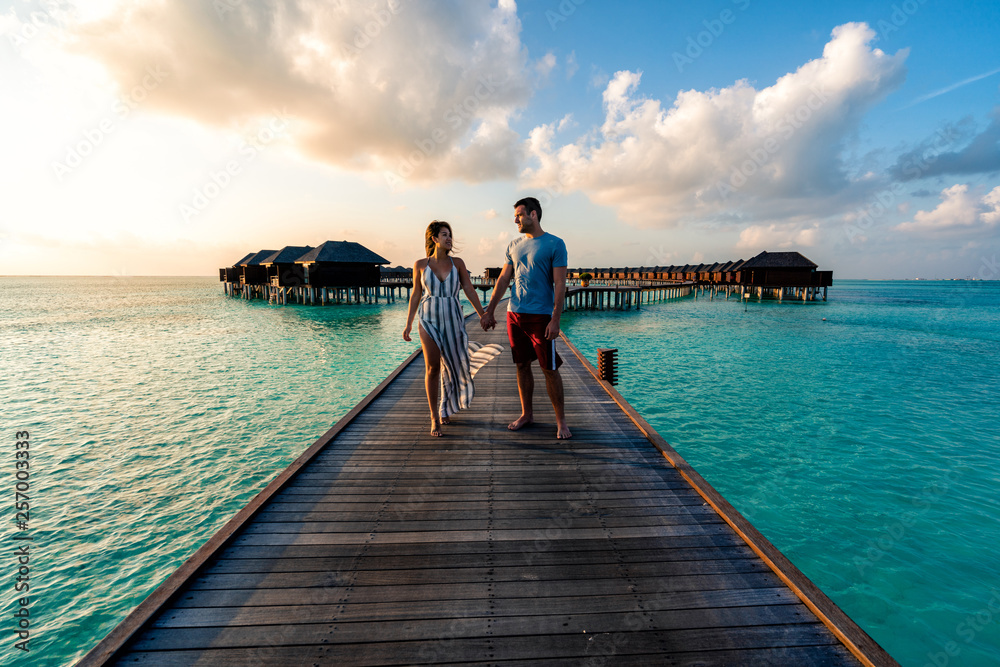 A couple enjoying a sunrise in the Maldives.  