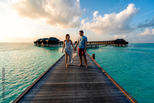 A couple enjoying a sunrise in the Maldives.   photo