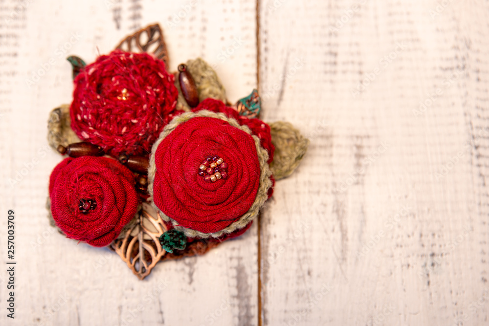 red boho brooch on wooden table red boho brooch on wooden table