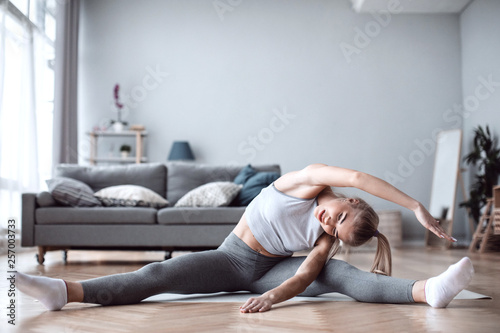 Attractive female doing exercise in her living room.