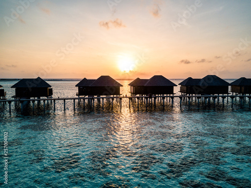 Aerial drone photo - A woman enjoying a sunrise in the Maldives