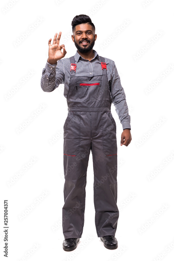 Indian man builder shows a okay hand gesture. Repair and construction. Isolated over white background Indian man builder shows a okay hand gesture. Repair and construction. Isolated over white background