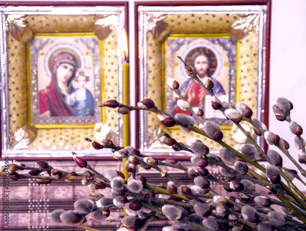 Obraz premium branches with willow fluffy flowers on the background of Christian icons