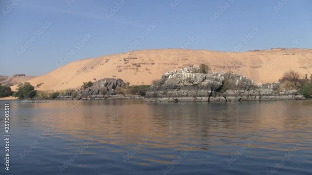 Sand Dune and Grey Rocks Adjacent to the Water of the River Nile in Egypt on a Sunny Day Sand Dune and Grey Rocks Adjacent to the Water of the River Nile in Egypt on a Sunny Day
