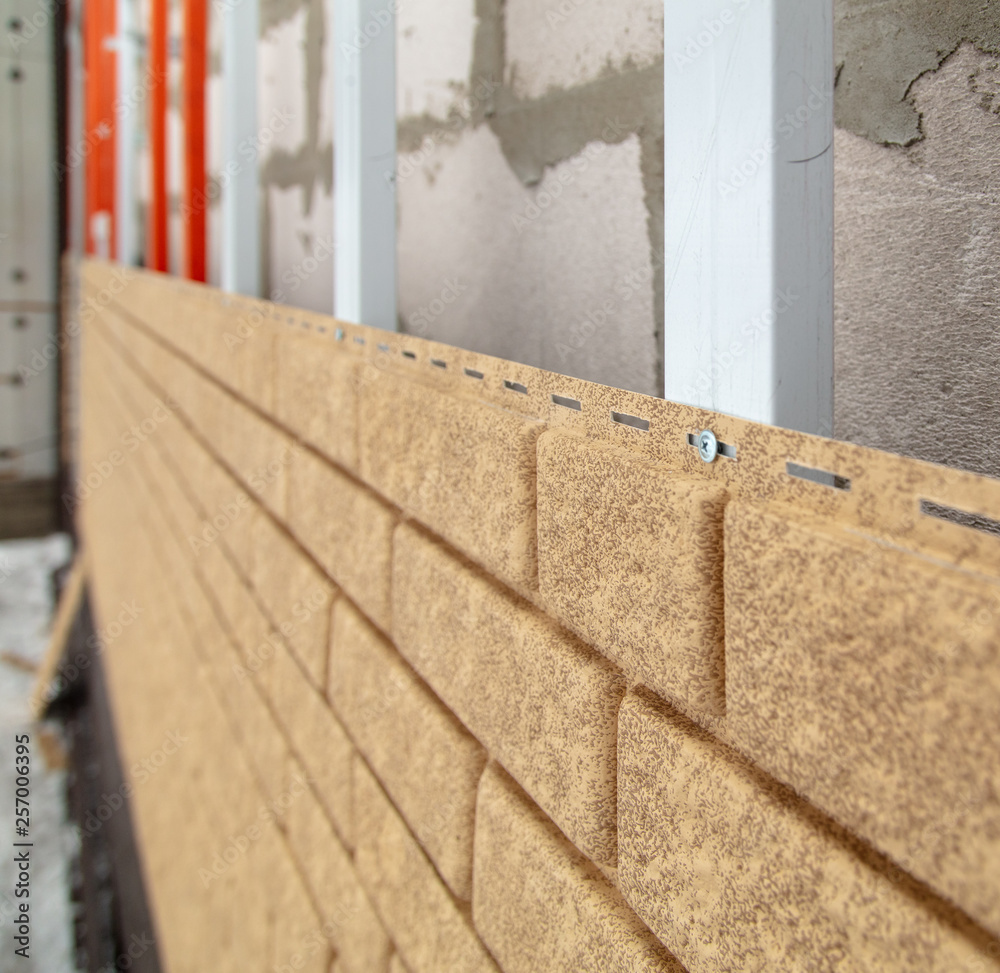 Installing brick siding on the wall of the house Installing brick siding on the wall of the house