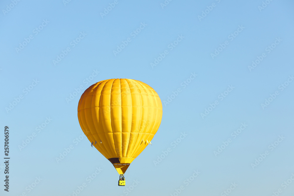 Naklejka premium Beautiful view of gold hot air balloon in blue sky. Space for text