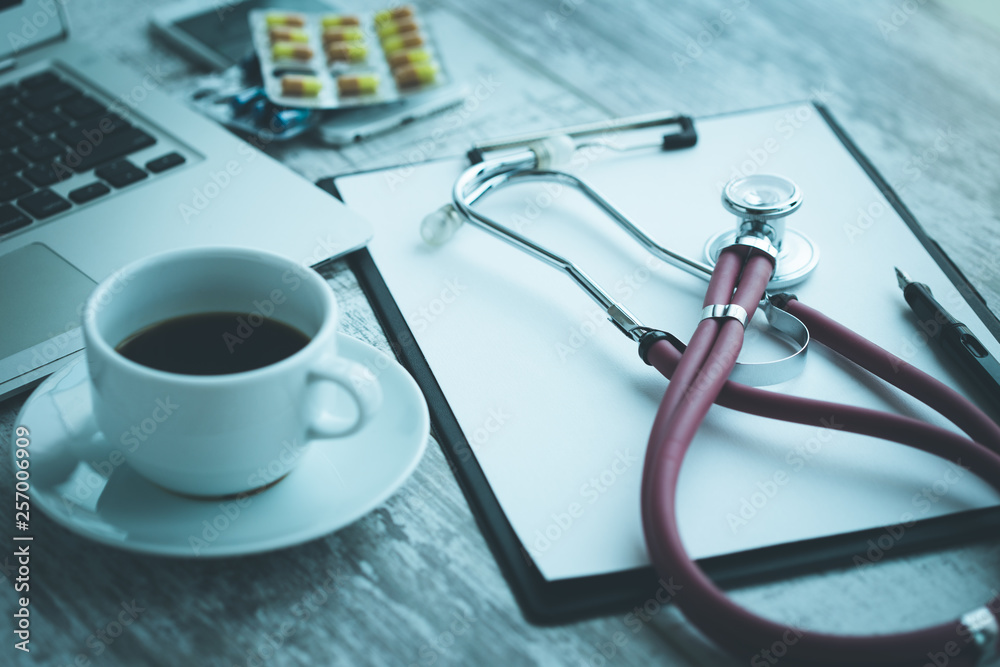 DOCTOR WORKPLACE WITH A STETHOSCOPE ON TABLE CONCEPT DOCTOR WORKPLACE WITH A STETHOSCOPE ON TABLE CONCEPT