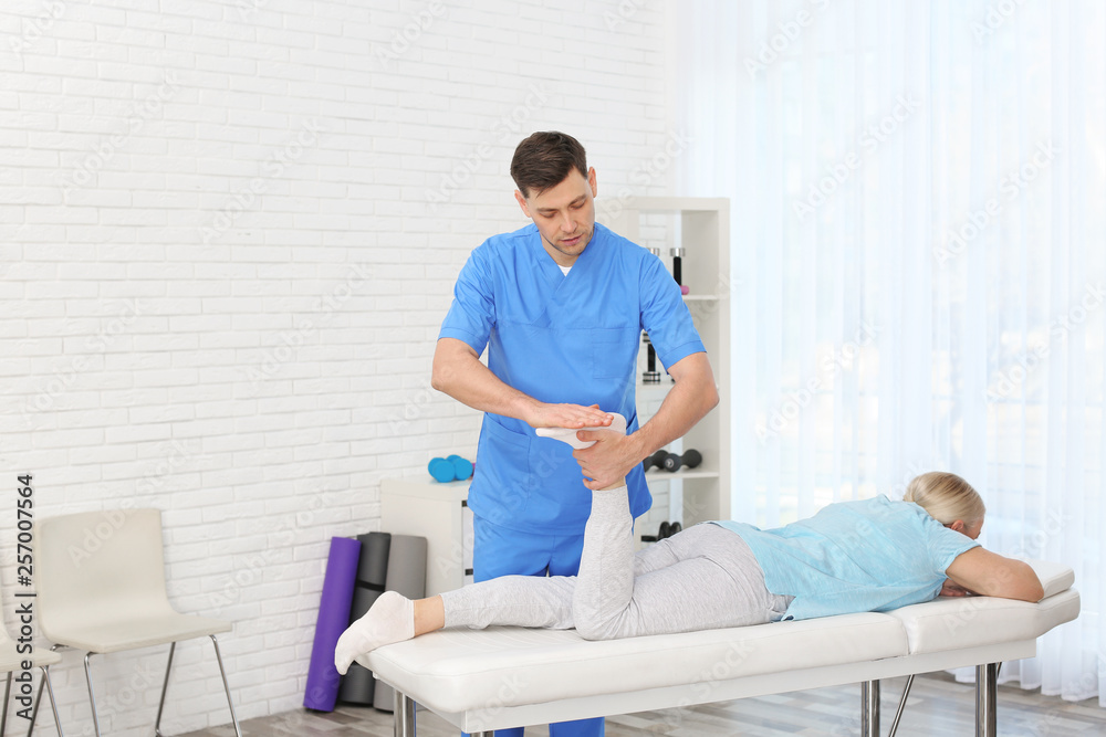 Fototapeta premium Physiotherapist working with patient in clinic. Rehabilitation therapy