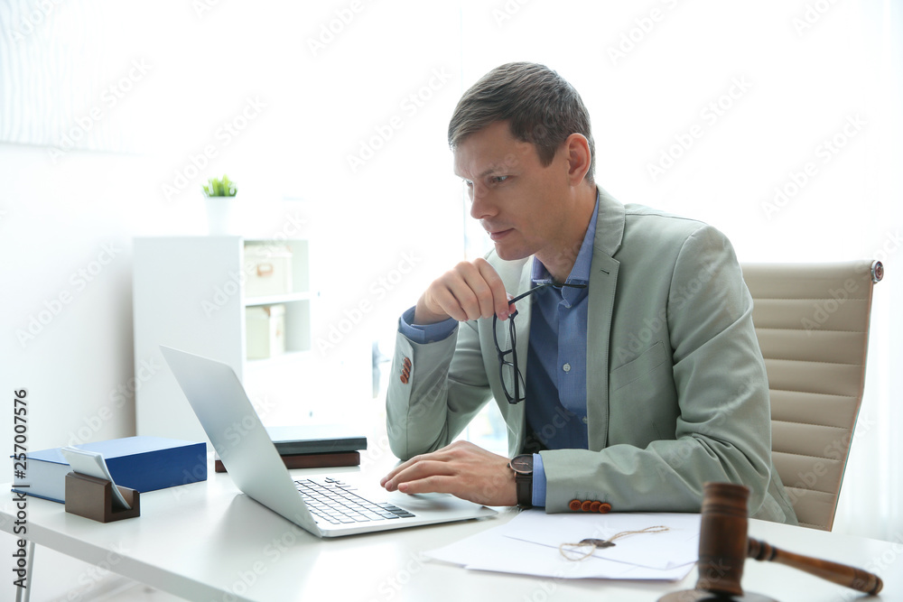 Notary working with laptop and judge gavel on table in office. Law and justice concept Notary working with laptop and judge gavel on table in office. Law and justice concept