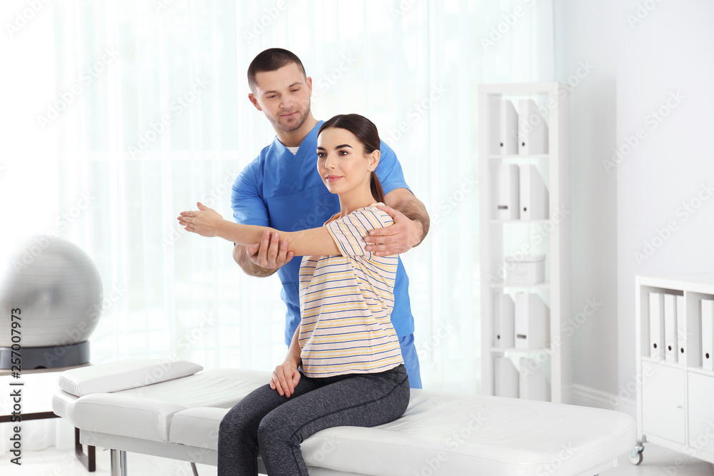 Fototapeta premium Doctor working with patient in hospital. Rehabilitation physiotherapy