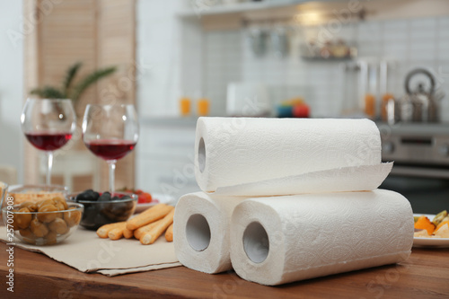 Rolls of paper towels on table in kitchen, space for text