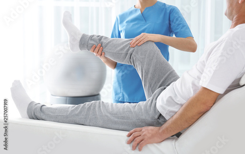 Doctor working with patient in hospital, closeup. Rehabilitation physiotherapy photo