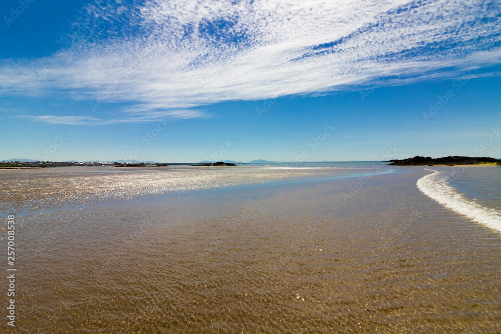 Summer coastal vista from Rhosneigr West Beach looking south-eastwards back to Rhosneigr & the Snowdonia Mountain Range, Anglesey, North Wales