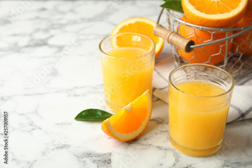 Composition with orange juice and fresh fruit on marble background, space for text
