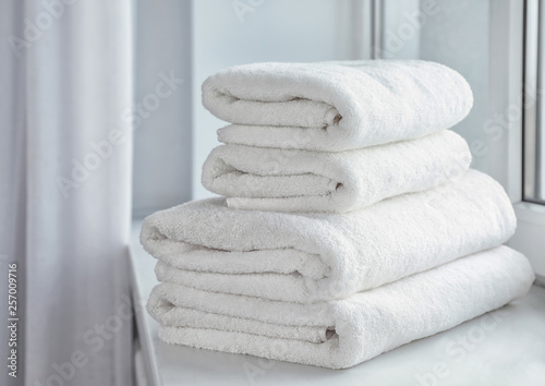 Stack of fresh soft towels on windowsill