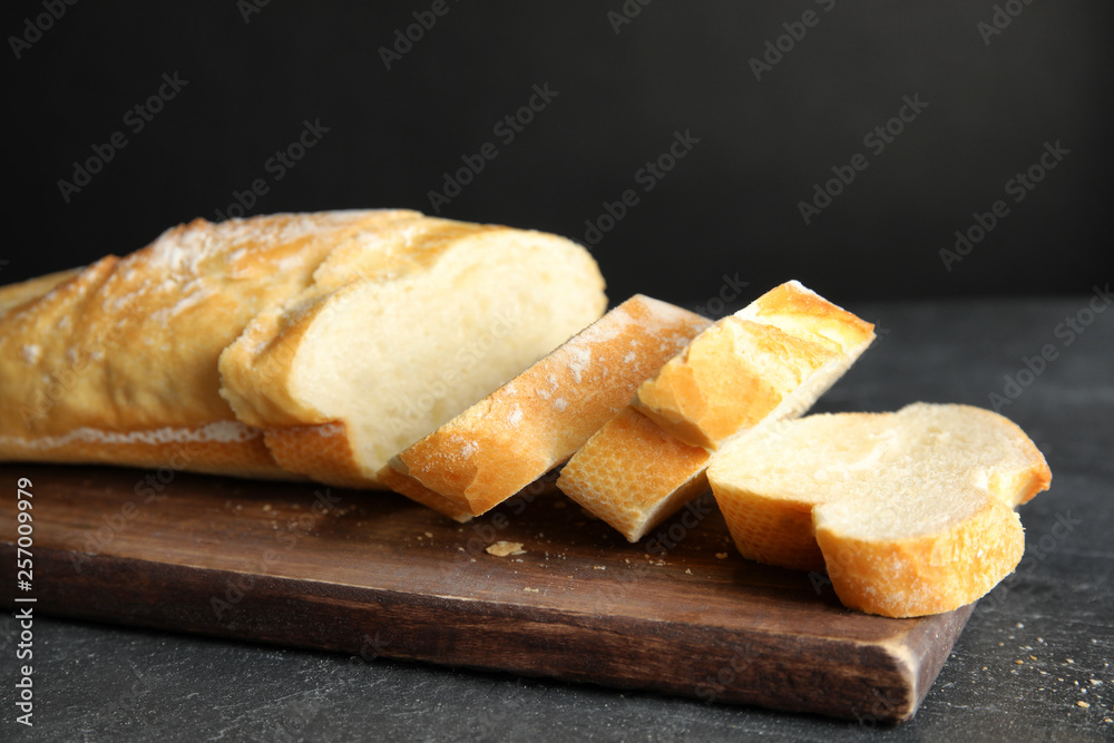 Board with tasty wheat bread on table