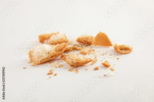Scattered bread crumbs on white background  closeup