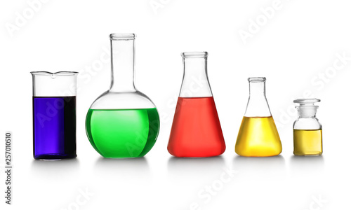 Laboratory glassware with different samples on white background. Solution chemistry