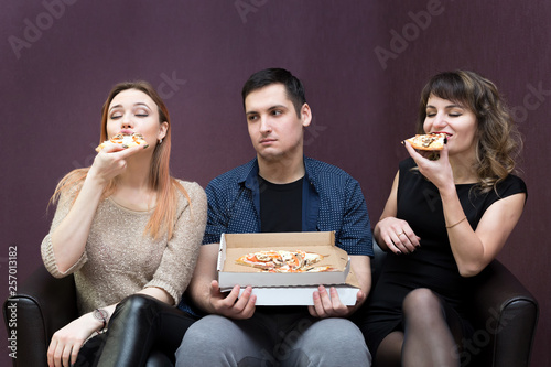 Fotografie A man because of illness can not eat pizza jealous girls