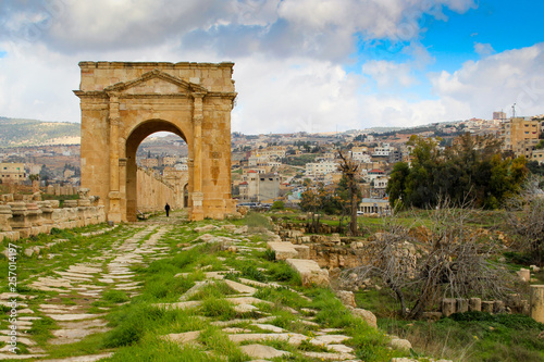 Path with Roman gate and cloudy blue sky at Jerash in Jordan