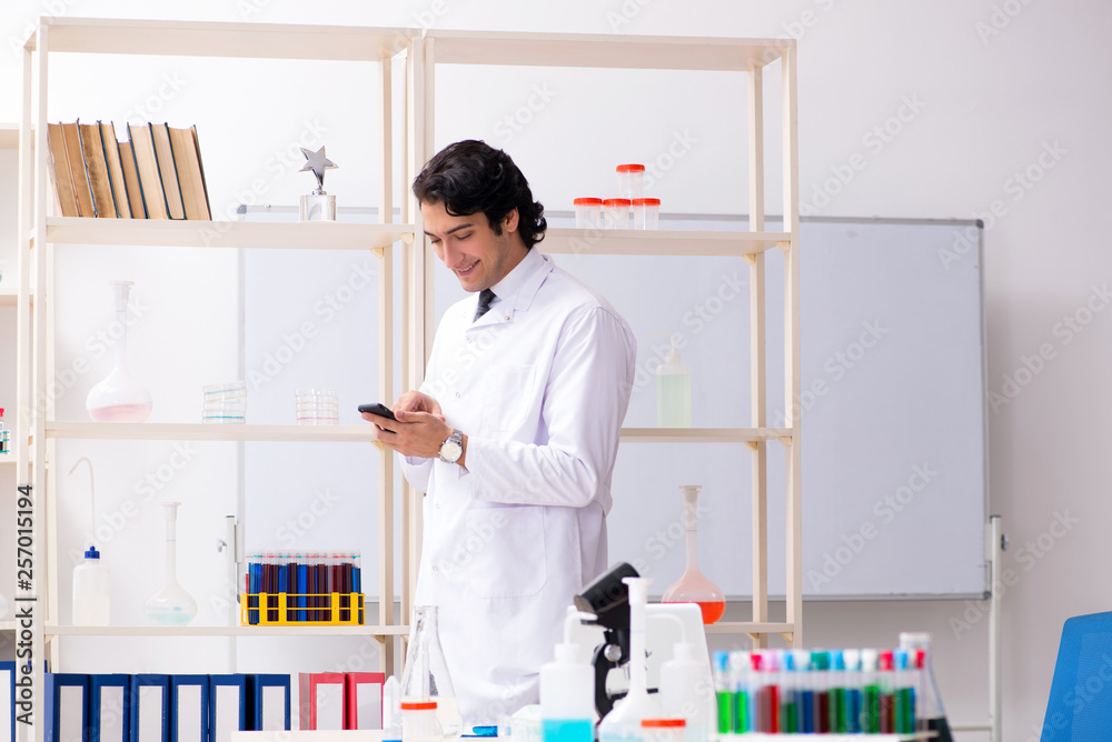 Young handsome chemist working in the lab Young handsome chemist working in the lab