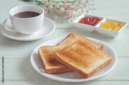 Toast bread on plate with jam and coffee cup