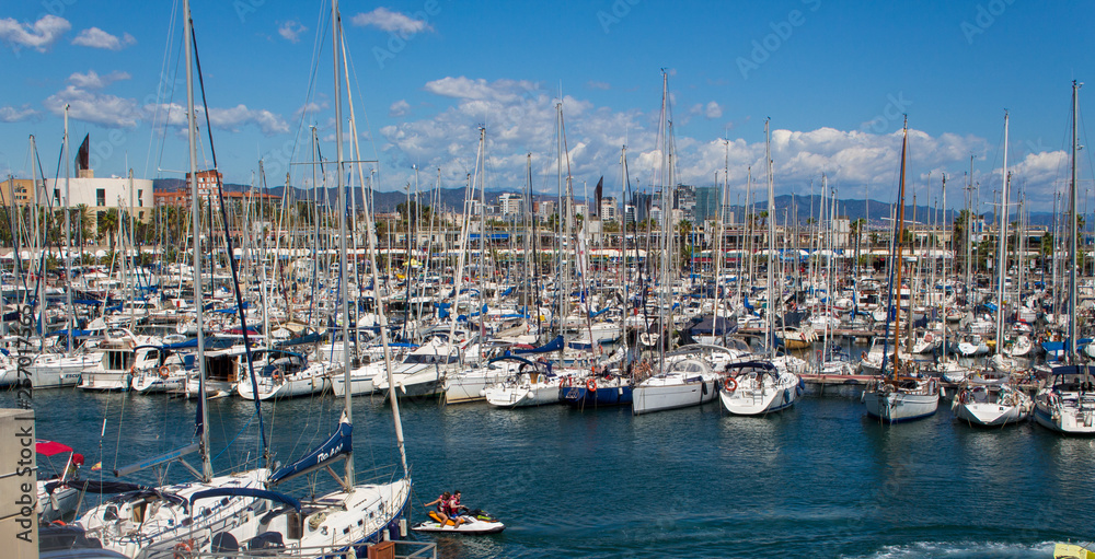 Sailing boats with blue and cloudy sky in harbor Barcelona 