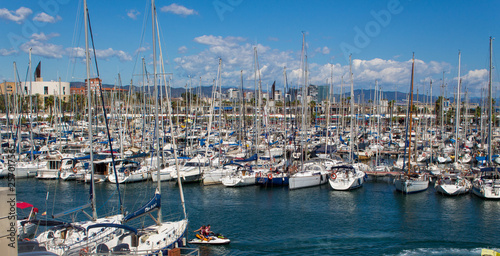 Sailing boats with blue and cloudy sky in harbor Barcelona  © John-Willem 