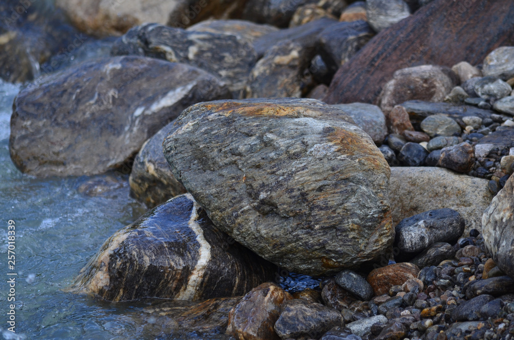 Fototapeta premium Wet round stones at the mountain river or sea or ocean shore